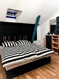 1 dormitorio con 1 cama con rayas blancas y negras en Große Wohnung in der KTV, en Rostock