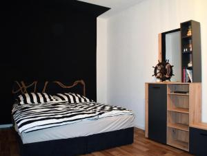 Un dormitorio con una cama en blanco y negro y un espejo en Große Wohnung in der KTV, en Rostock 7 fotos más