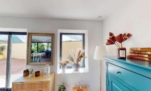 ein Zimmer mit einer blauen Kommode und einem Spiegel in der Unterkunft Maison familiale entre mer et campagne in Putot-en-Bessin