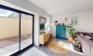 ein Wohnzimmer mit Sofa und Tisch in der Unterkunft Maison familiale entre mer et campagne in Putot-en-Bessin