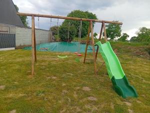 einen Spielplatz mit einer grünen Rutsche im Hof in der Unterkunft Family Home Between Land Sea Maison Familial Entre Terre et Mer Avec piscine in Plédran + 35 Fotos