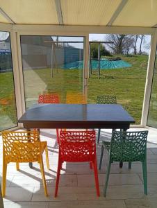 ein Tisch mit bunten Stühlen drumherum in einem Zelt in der Unterkunft Family Home Between Land Sea Maison Familial Entre Terre et Mer Avec piscine in Plédran
