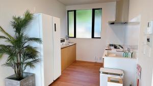 cocina con nevera y maceta en 父母ヶ浜リゾートヴィラ Senja, en Mitoyo
