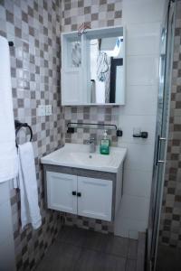 Un baño con lavabo, espejo y ducha. en Blue sky apartment, en Kigali
