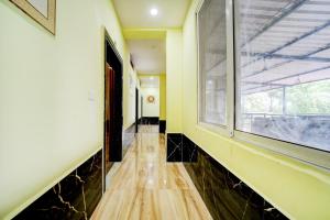 an empty hallway with a window and a wooden floor at SPOT ON Parampara Garden Resort in Shamsgarh