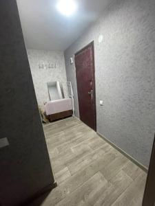 pasillo con puerta y silla en una habitación en Квартира в изюме, en Izyum
