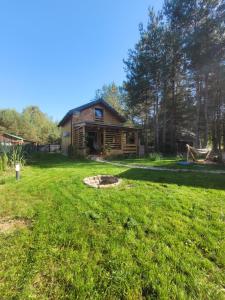 a log home with a fire pit in the yard at Zalasek - miniSPA, rowery, łódka, relaks in Bołtryki