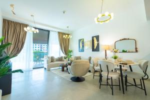 a living room with a table and chairs at Al Raha Beach Elegant 2BR Apartment with Private Balcony in Abu Dhabi