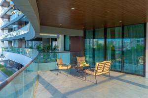 a balcony with chairs and a table in a building at Al Vera Elegant 2BR Apartment Private Balcony in Abu Dhabi