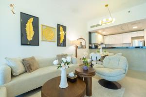 a living room with a couch and a chair and a table at Al Raha Beach Elegant 2BR Apartment with Private Balcony in Abu Dhabi +42 photos