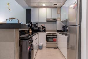 a kitchen with white cabinets and stainless steel appliances at Al Raha Beach Elegant 2BR Apartment with Private Balcony in Abu Dhabi