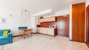 una cucina e un soggiorno con un divano blu e un tavolo di Flatbook Apartamenty - Krynica Morska Margo a Krynica Morska
