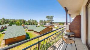 balcone con sedie e vista su un fienile. di Flatbook Apartamenty - Krynica Morska Margo a Krynica Morska