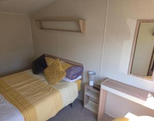 Un dormitorio pequeño con una cama y un espejo. en 61, Stowford Gardens, en Combe Martin 52 fotos más