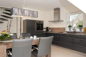 a kitchen with black cabinets and a table with chairs at Perle von Borkum 2 in Borkum +7 photos