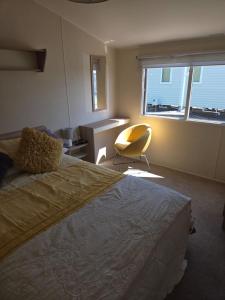 Un dormitorio con una cama, una silla y una ventana en 61, Stowford Gardens, en Combe Martin