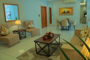 a living room with chairs and a table with flowers on it at Bahria Sunrise Apartments in Rawalpindi