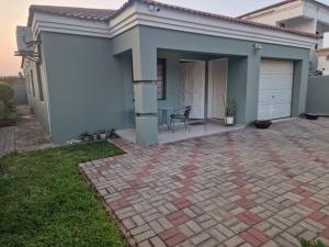 a house with a brick patio in front of it at Luxe Comfort Retreat in Gaborone +5 photos