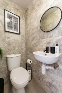 une salle de bain avec toilettes, lavabo et miroir dans l'établissement New! Delightful 2BR Flat in Woolwich, à Plumstead