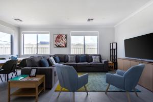a living room with a couch and a flat screen tv at Barefoot2beach By Swan Bnb Management in Yanchep
