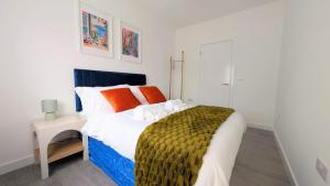 une chambre avec un grand lit avec des oreillers orange dans l'établissement New! Delightful 2BR Flat in Woolwich, à Plumstead