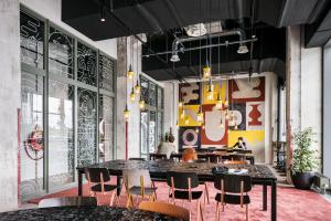 マーストリヒトにあるThe Social Hub Maastricht Extended Stayのテーブルと椅子があり、壁に落書きがあるダイニングルーム +18枚の写真