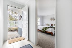 Un dormitorio blanco con una cama y un espejo. en Barefoot2beach By Swan Bnb Management, en Yanchep