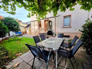 a table and chairs with a grill in a backyard at Villa Rumpenheim in Muhlheim am Main