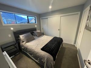 a bedroom with a bed and a window at Spa apartment in Queenstown in Queenstown Airport