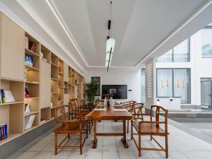 a dining room with a table and chairs at Floral Shemanyue Mountain Homestay in Huangshan