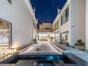 an external view of a building with a pool at Floral Shemanyue Mountain Homestay in Huangshan