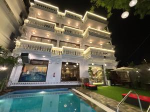 阿格拉Walk 2 Taj A Boutique Abode的一座前面有游泳池的建筑