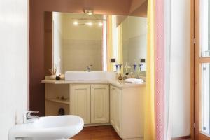 a bathroom with a sink and a mirror at La Casa di Alice in Tavernerio +12 photos