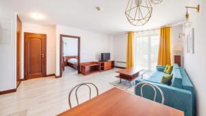 un soggiorno con un divano blu e un tavolo di Flatbook Apartamenty - Krynica Morska Margo a Krynica Morska