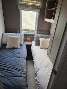 ウィットリー・ベイにあるLighthouse and sea viewsの窓のある小さな部屋にベッドが2つある
