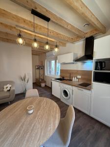 a kitchen with a table and a dining room at La Petite Couze, Maison cozy pour 2 en Auvergne in Le Breuil-sur-Couze