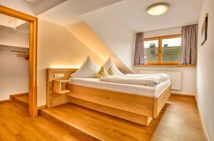 ein Schlafzimmer mit einem Bett in einem Zimmer mit einem Fenster in der Unterkunft Pension Zum Rechen in Bodenmais