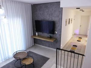 a living room with two chairs and a flat screen tv at Mandala- וילה יוקרתית לאירוח&אירועים עם ג'קוזי ובריכה פרטית שקט מושלם שלווה ונוף עוצר נשימה 