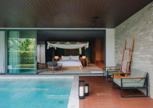 sypialnia z łóżkiem i basenem w obiekcie Nimman Private Luxury Pool Villa Resort Khao Yai w mieście Ban Rai Khlong Sai