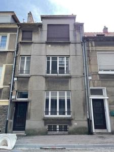 a building with windows and doors on a street at Le Cottage du Centre in Boulogne-sur-Mer
