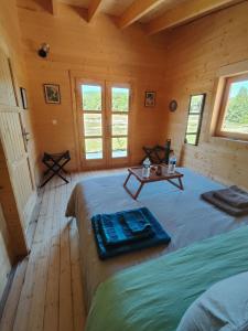 two beds in a room with wooden floors and windows at Au chant des oiseaux Mésanges Varen in Varen