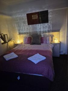 a bedroom with a large bed with towels on it at Amarillys Guest House in Preston