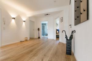 un soggiorno vuoto con pareti bianche e pavimenti in legno di Kleeoase - Luxus Apartment- Jacuzzi - Dachterrasse - Kochinsel - kostenlose Parkplätze - See in 10 min a Greifenstein Altre 39 foto