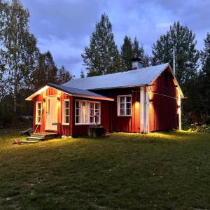 a red house with lights on the side of it at Savupirtti 1819 in Pudasjärvi