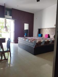 Un dormitorio grande con una cama grande y una mesa. en Abimayu Gardern, en Covelong