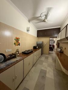 a large kitchen with white cabinets and a sink at Bienvenue Homestay in Panchkula
