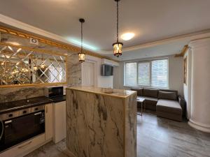 a kitchen with a counter and a living room at Central Park Street Apt in Chişinău