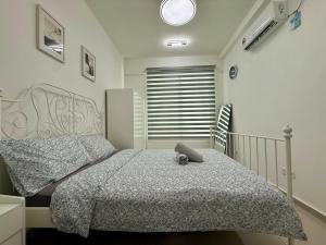 Un dormitorio con una cama con un animal de peluche encima. en Charming 2BR in Novo 8 Residence w-1 Free Parking, en Melaka