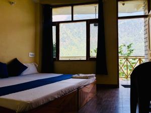 a bedroom with a bed and two windows at Airship Manali - A Mountain View Hotel in Manāli +36 photos