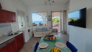 a kitchen with a table and a sink and a television at B&B "Raggio di Sole" in Le Castella